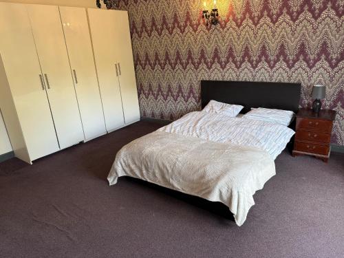 a bedroom with a bed and a wall at Lux spacious 3BR entire apartment in Wakefield