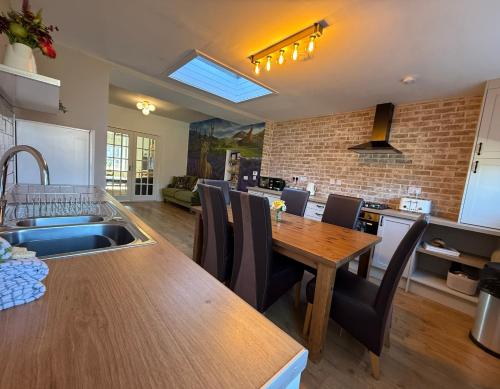 a kitchen and dining room with a wooden table at Wells Street Cottages No 26 By The River Ness in Inverness