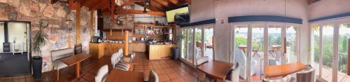 a room with a kitchen with chairs and a table at Casa Alta Hotel Boutique & Spa - Solo Adultos in Villa Carlos Paz
