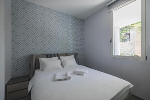 a bedroom with a bed with two towels on it at Villa Solaria in Sveti Stefan