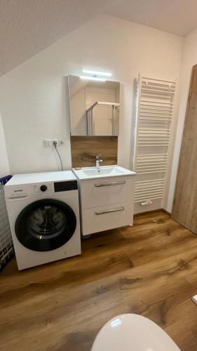 a bathroom with a washing machine and a sink at 3er Apartment Boardinghouse Gavner in Apen in Apen