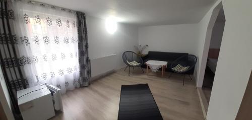 a living room with two chairs and a window at Casa Anastasia in Bicaz