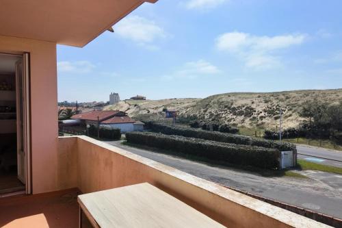 d'un balcon avec une table et une vue sur la rue. dans l'établissement Les Semis, à Soorts-Hossegor