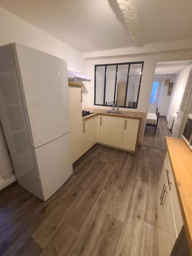 une cuisine vide avec un réfrigérateur et une table dans l'établissement Appartement T2 à 100m du port, à La Seyne-sur-Mer