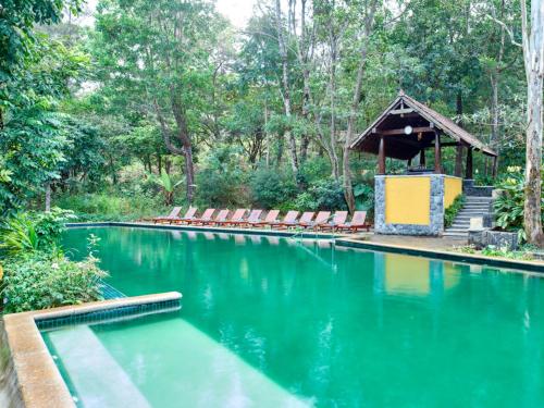 una piscina con sillas y un cenador en Club Mahindra Madikeri, Coorg, en Madikeri