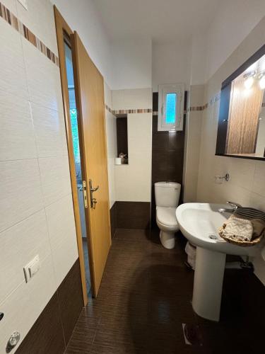 a bathroom with a white sink and a toilet at Hectora -Private Sunrise Retreat in Kerveli