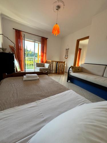 a bedroom with a bed and a couch and a window at Hectora -Private Sunrise Retreat in Kerveli