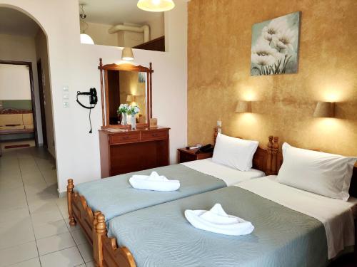 two beds in a hotel room with towels on them at Borianoula Apartments in Frý
