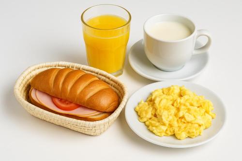 a table with a plate of breakfast foods and a cup of orange juice at Hotel Tiwintza Internacional in Quito