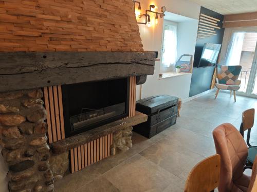a fireplace in a living room with a stone wall at Un Coin De Gîtes in Sciez