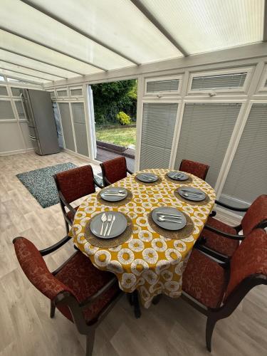a table with chairs and a table cloth on it at Spacious 3 bed house garden & parking sleeps 5 in Belvedere