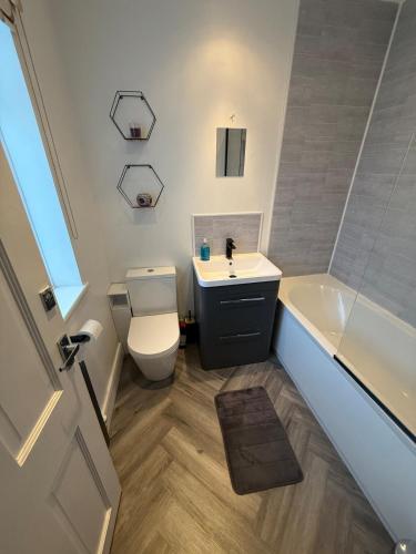 a bathroom with a toilet and a sink and a tub at Spacious 3 bed house garden & parking sleeps 5 in Belvedere