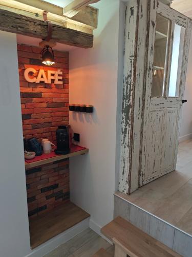 an open door with a cafe sign on a brick wall at Un Coin De Gîtes in Sciez