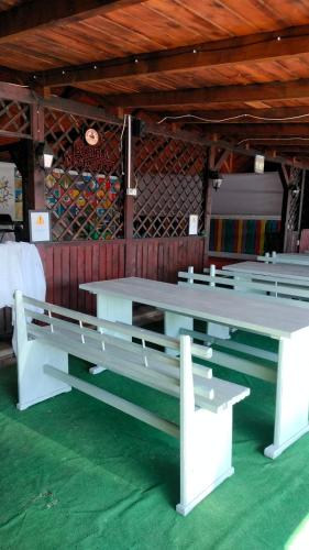 two white benches sitting inside of a building at Casa Emil in Floreşti