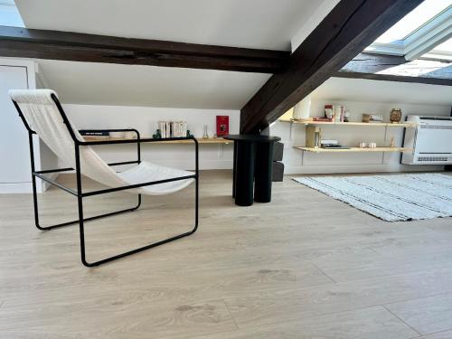 un salon avec une chaise et une table dans l'établissement T2 sous les toits, entre gare et centre-ville, Grands buffets, à Narbonne