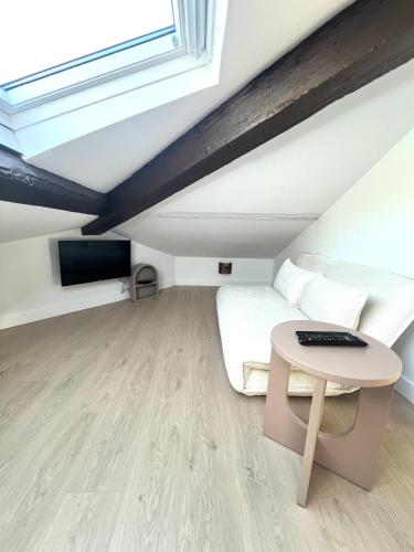 une petite pièce avec un lit et une table dans l'établissement T2 sous les toits, entre gare et centre-ville, Grands buffets, à Narbonne