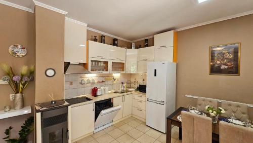 a kitchen with white cabinets and a white refrigerator at Lalovina Apartment in Herceg-Novi
