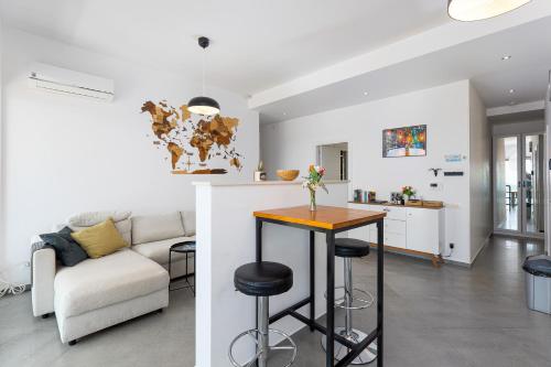 a kitchen and living room with a table and a couch at Modern Top Floor Sea View 3BR with Pools, Spa & Fitness in Becici