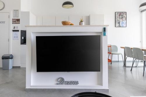 a flat screen tv in a living room at Modern Top Floor Sea View 3BR with Pools, Spa & Fitness in Becici