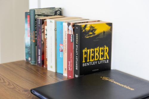 a row of books sitting on a table with a laptop at Modern Top Floor Sea View 3BR with Pools, Spa & Fitness in Becici