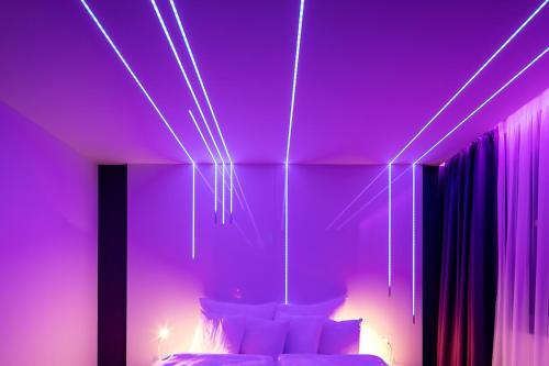 a purple room with a bed with white pillows at Pytloun Grand Hotel Imperial in Liberec