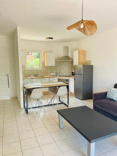 une cuisine et un salon avec une table et un canapé dans l'établissement Fiori di Luna, à Porto-Vecchio