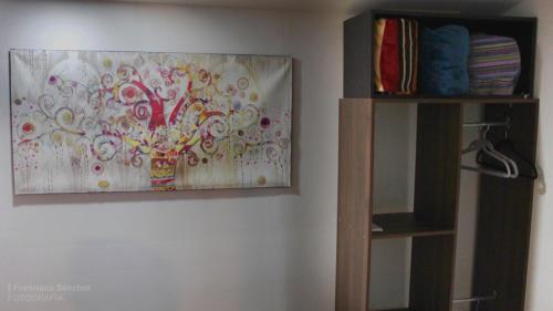 ein Gemälde, das an einer Wand neben einem Regal hängt in der Unterkunft Cozy family apartment, kitchen in Mineral del Monte