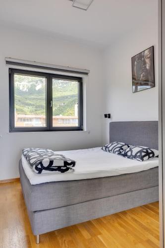 a bed in a room with a large window at Modern Top Floor Sea View 3BR with Pools, Spa & Fitness in Becici