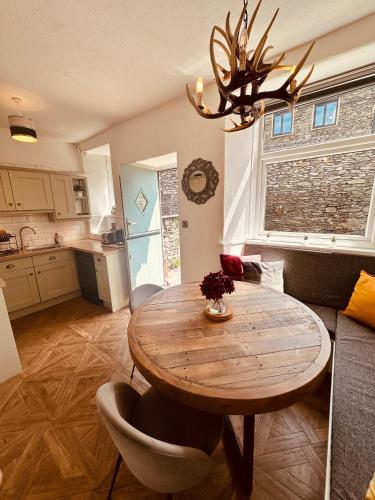 a kitchen and dining room with a wooden table at Woodland Cottage - private courtyard - Pet Friendly Retreat in the heart of Windermere in Windermere