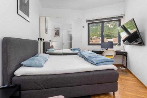 a bedroom with two beds and a desk at Modern Top Floor Sea View 3BR with Pools, Spa & Fitness in Becici