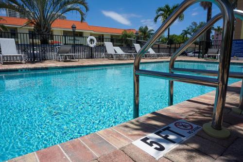 a swimming pool at a hotel with a number on it at Haven - Walk to the Beach, Free Bikes, and Pool! in Palm Beach Shores