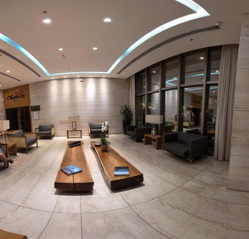 a lobby with couches and a table in a building at Flat Hilton inn - Belo Horizonte 1005 in Belo Horizonte