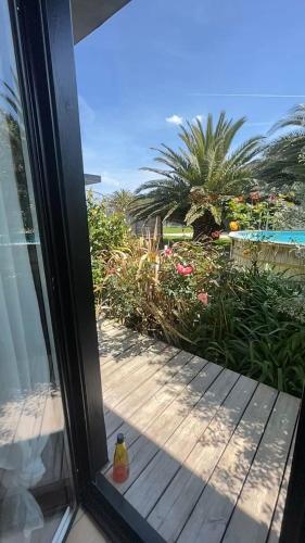 une porte coulissante en verre avec vue sur une cour dans l'établissement Maison Goa Portsall, à Ploudalmézeau