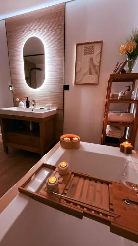 La salle de bains est pourvue d'une baignoire avec un lavabo et un miroir. dans l'établissement Maison Goa Portsall, à Ploudalmézeau