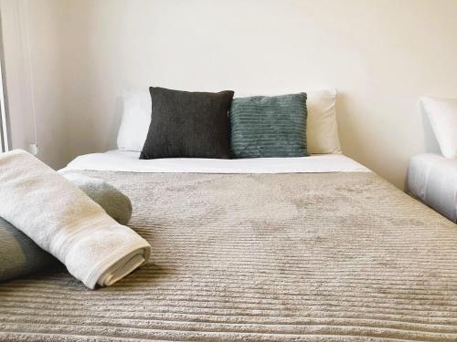 a bed with two pillows on it in a room at Departamento cerca Solca, Embajada Americana y Estadio Atahualpa con vista al COTOPAXI y la CIUDAD in Quito