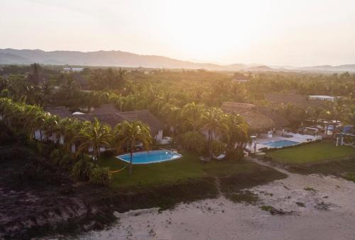 an aerial view of a resort with palm trees at Villa Lumina - Beachfront Escape Private Pool, Spacious & Serene in Paso Hondo