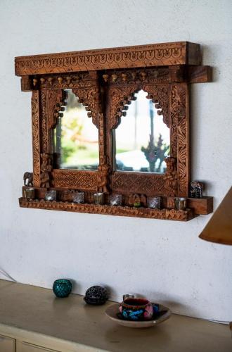 a mirror on a wall with a plate on a table at Villa Lumina - Beachfront Escape Private Pool, Spacious & Serene in Paso Hondo