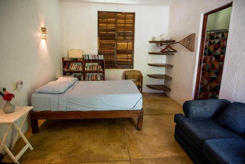 a small bedroom with a bed and a couch at Villa Lumina - Beachfront Escape Private Pool, Spacious & Serene in Paso Hondo