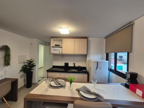 a kitchen and dining room with a table and chairs at Studio Novo e completo perto da PUC in Curitiba
