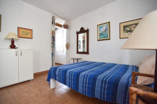 a bedroom with a bed with a blue striped blanket at OLD TOWN 5 apartment in Budva