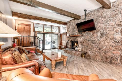 a living room with a stone wall at Beaver Creek West Mountain Condo in Avon