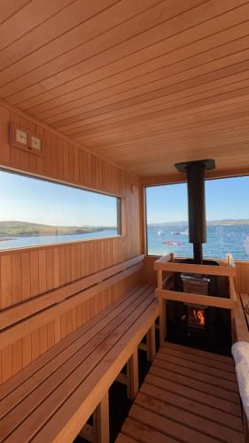a sauna with a fireplace and two windows at Audley's in Lettermullan
