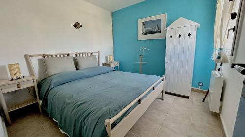 une chambre avec un lit et un mur bleu dans l'établissement Appartement avec vue imprenable sur la mer et le lydia 5EST106, au Barcarès