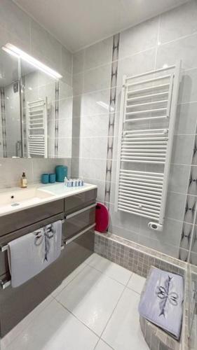 une salle de bain avec un lavabo et une douche avec un miroir dans l'établissement Appartement avec vue imprenable sur la mer et le lydia 5EST106, au Barcarès