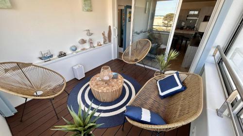 un balcon avec des chaises en rotin et une table sur un porche dans l'établissement Appartement avec vue imprenable sur la mer et le lydia 5EST106, au Barcarès