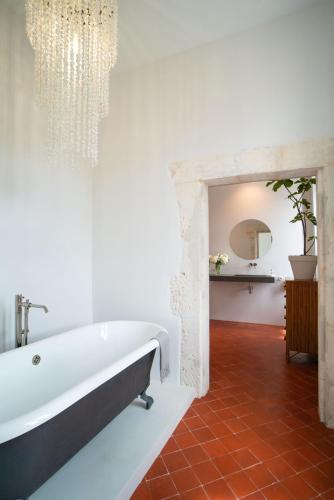 La salle de bains est pourvue d'une grande baignoire et d'un miroir. dans l'établissement Le petit Mas du village, à Saint-Rémy-de-Provence