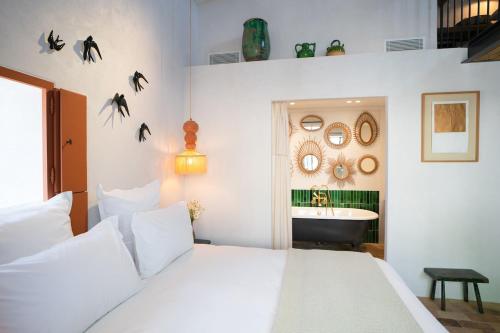 - une chambre avec un lit blanc et un lavabo dans l'établissement Le petit Mas du village, à Saint-Rémy-de-Provence