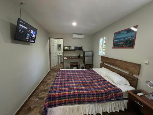 a bedroom with a bed and a tv on the wall at Hotel Casa Miramar in Tamanique