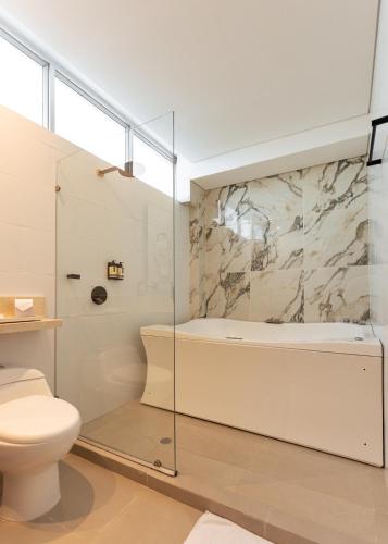 a bathroom with a shower and a tub and a toilet at Hotel Zi One Luxury in Cartagena de Indias