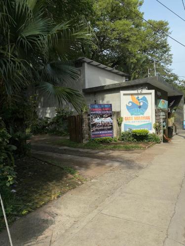 a building with a sign next to a street at Hotel Casa Miramar in Tamanique